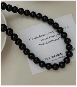 Close-up of minimalist black beaded S925 silver necklace with glass crystal beads