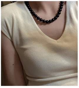 Detail of S925 silver black beaded necklace with glass crystal beads on model's neck