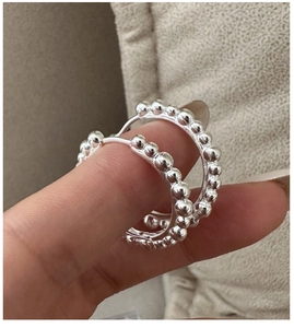 Gros plan détaillé de créoles perlées en argent 925 avec une texture vintage