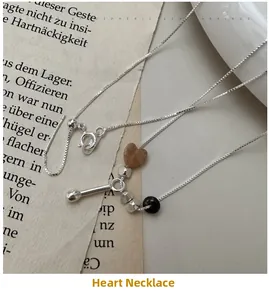 Detail of S925 silver necklace with heart stone and beads on vintage newspaper