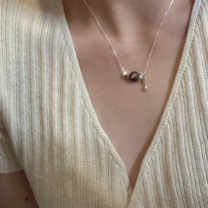 Minimalist S925 silver necklace with teardrop wood bead pendant worn on beige knitwear