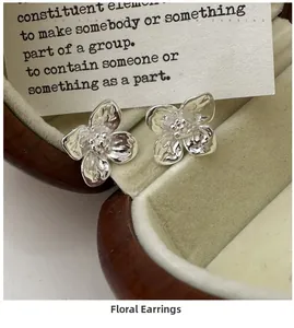 Detailed macro shot of S925 sterling silver flower stud earrings on vintage wooden box