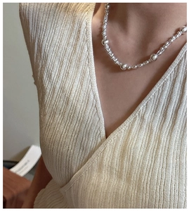 Detailed view of 925 sterling silver beaded layered necklace on a model's neck