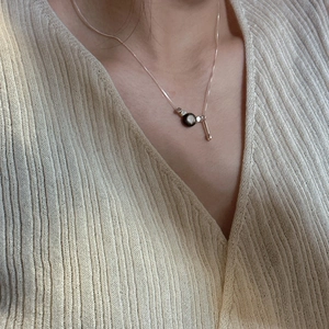Minimalist S925 sterling silver necklace with dark bead and metal bar pendant on neck