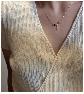 Close-up of S925 silver necklace featuring natural stones and bar pendant on a model