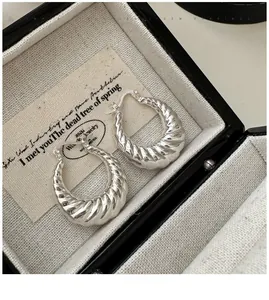 Gros plan de boucles d'oreilles croissant en argent S925 dans un écrin à bijoux noir