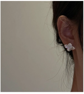 Close-up of S925 sterling silver floral stud earring with layered petals on ear