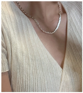 Detail of S925 sterling silver frosted bean necklace on model with knit sweater