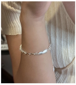 Detailed view of matte silver leaf-shaped links on adjustable S925 sterling silver bracelet