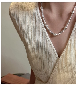 Detail of 925 sterling silver beaded necklace on model neck with minimalist jewelry design