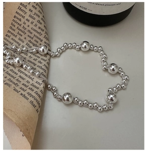 Detail of multi-layered silver bead necklace with high-polish metallic spheres