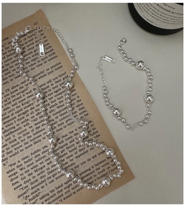 Detail of AG925 silver beaded necklace set with lobster clasp and tag on vintage paper