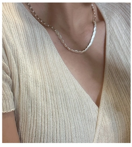Macro shot of S925 sterling silver frosted beaded necklace on a model wearing V-neck top