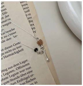 Detailed view of S925 silver necklace with marble heart pendant on vintage book pages