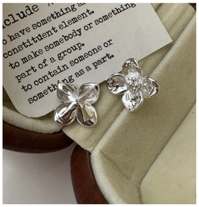 Macro shot of S925 sterling silver four-petal flower earrings with textured finish