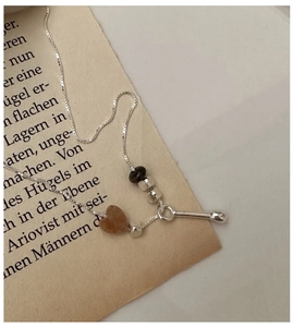 Macro view of S925 silver necklace featuring a brown heart stone and retro pendant details