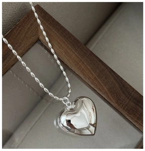 Vue détaillée du pendentif cœur poli en argent S925 sur une chaîne à perles de riz épurée