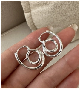 Detail view of S925 sterling silver knotted double hoop earrings with a polished finish