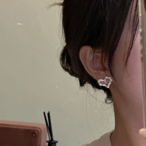Orecchini a cuore in argento sterling S925 con finitura lava indossati da una modella