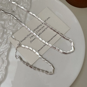 Minimalist S925 sterling silver frosted bean necklace and bracelet set on white porcelain