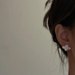 Minimalist S925 sterling silver flower stud earrings with vintage metallic texture on ear