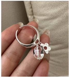 Detailed close-up of S925 sterling silver ring with crystal bead and floral charm pendant
