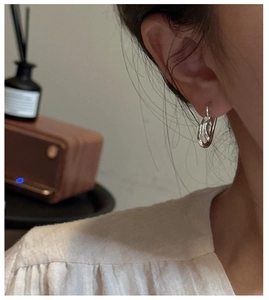 Detail of S925 sterling silver knot earrings on model for a minimalist vintage aesthetic