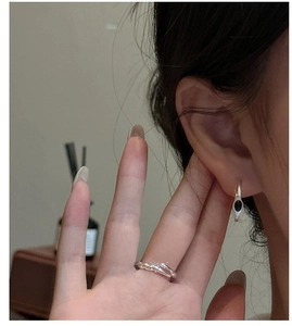 Close-up of 925 silver twist ring and hoop earrings with black onyx on model