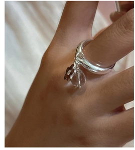 Detail of S925 silver ring featuring a brown flower charm and crystal teardrop bead