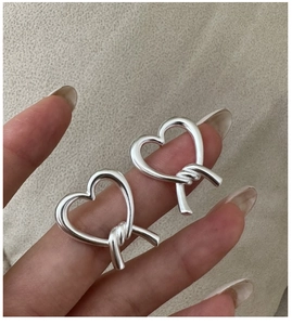 Macro shot of S925 sterling silver hollow heart earrings with elegant rope knot design