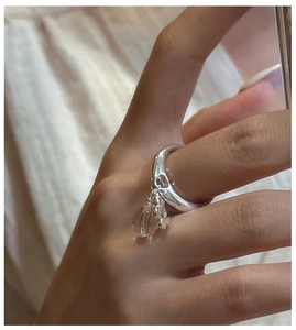 Macro shot of S925 sterling silver ring featuring a white crystal bead and flower charm
