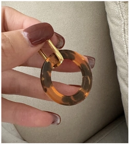 Detail of S925 silver gold hoop earring featuring leopard print resin circle charm