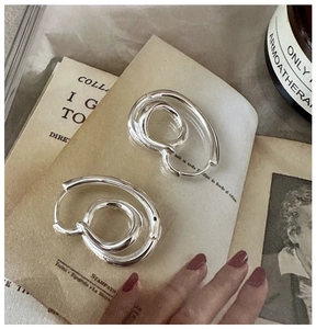 Macro shot of S925 sterling silver knotted hoop earrings with vintage twisted texture