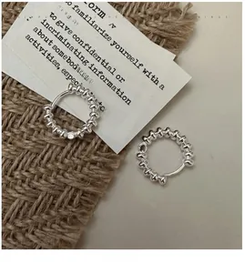 Detailed view of S925 sterling silver beaded hoop earrings on a textured linen background