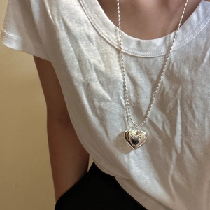 Collier avec pendentif cœur en argent sterling S925 et chaîne à perles sur un t-shirt