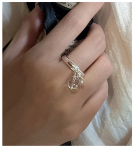 Detail of S925 sterling silver ring with clear crystal drop worn on a finger