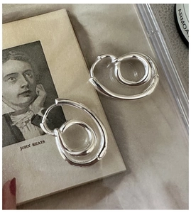 Macro detail of S925 sterling silver knotted hoop earrings with vintage twisted design