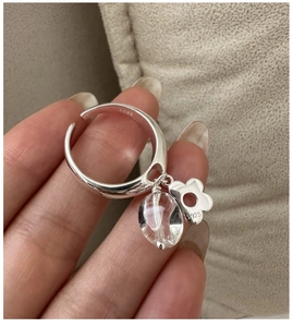 Detail of S925 sterling silver ring featuring a clear crystal bead and hollow flower charm