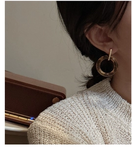 Close-up of vintage amber resin hoop earrings worn by a model in knitwear
