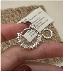 Macro detail of S925 sterling silver beaded hoop earrings with a textured metal finish