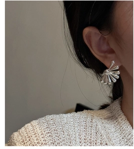 Detail of S925 silver flower stud earring shown on model with irregular sunburst design