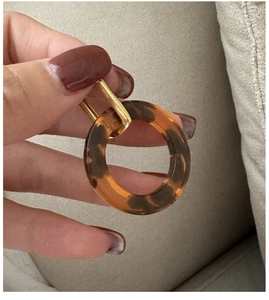 Detail of vintage leopard print resin hoop earring with gold metallic cylinder clasp