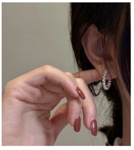 Close-up of minimalist S925 sterling silver beaded hoop earring worn by a model