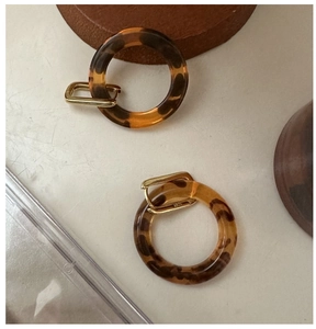 Detail of S925 sterling silver gold earrings with vintage leopard pattern resin rings