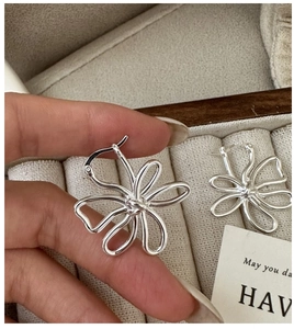 Gros plan sur les boucles d'oreilles fleur en argent S925 avec poinçon authentique