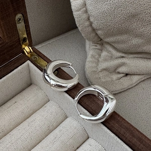 Orecchini a cerchio spessi in argento sterling S925 lucido su una scatola di legno per gioielli