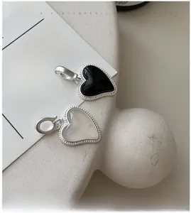 Détail de pendentifs en agate en forme de cœur avec bords perlés argentés et fermoir
