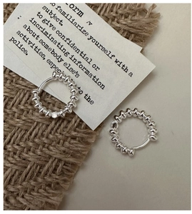 Close-up of S925 sterling silver beaded hoop earrings on rustic linen background