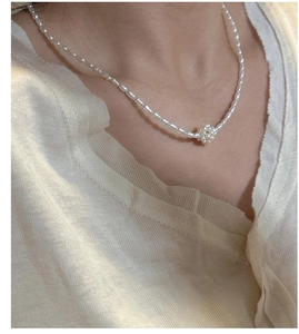 Detail view of S925 silver necklace with white rice pearls and floral pearl pendant