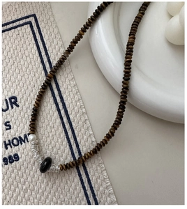 Vue détaillée d'un collier rétro avec perles en bois marron et perle blanche élégante